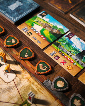Portrait macro product photography of Lord of the Rings Duel Middle Earth showing Free Peoples faction tokens with horn sphere and tree leaf symbols designed by Antoine Bauza and Bruno Cathala