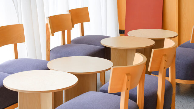 Modern cafe seating area with round wooden tables and chairs in minimal design, Perspective side view