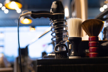 Fototapeta premium Shaving brush white bristles, palm brush black bristles, red handle brush sitting on dark counter