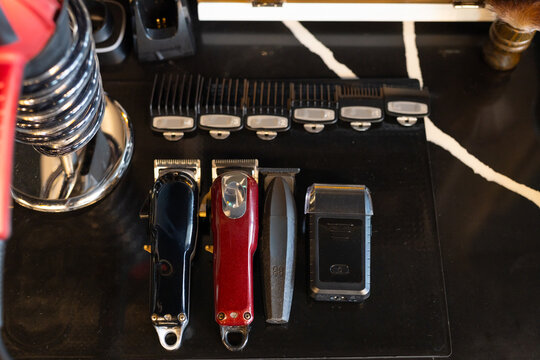 Four grooming devices are sitting on black anti-slip mat on marble-look countertop, guards aligned