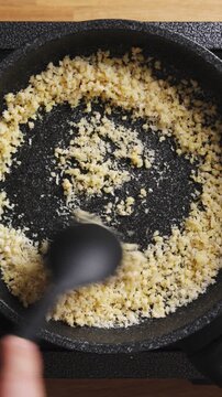 Chopped almonds mix with panko breadcrumbs in frying pan. Almonds toast until golden, adding crunch to breadcrumb mix. Almond topping works great for baked dinner recipes at home.