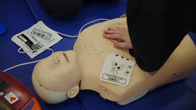 Person learning cpr and aed on a medical dummy