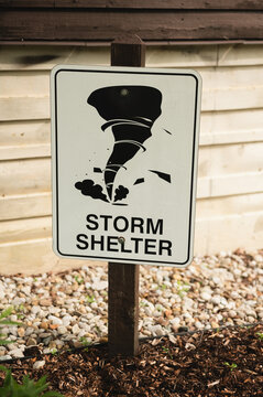 A storm shelter sign featuring a tornado symbol marks the location of an emergency shelter for severe weather events. This image highlights tornado preparedness, public safety, and emergency planning