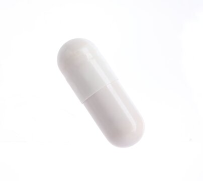 One pill on white background. Health supplement