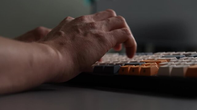 Close-up cropped shot of male hands typing quickly on custom mechanical keyboard. Fingers press keys during work, coding, gaming. Focus on productivity digital workflow in modern office home setting.