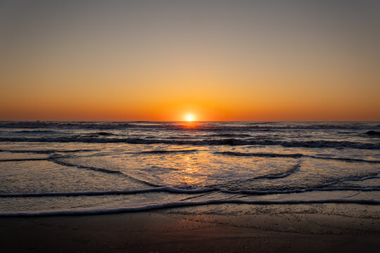 Stunning sunrise over the horizon on a vast ocean beach at Corolla, NC, Outer Banks (OBX)