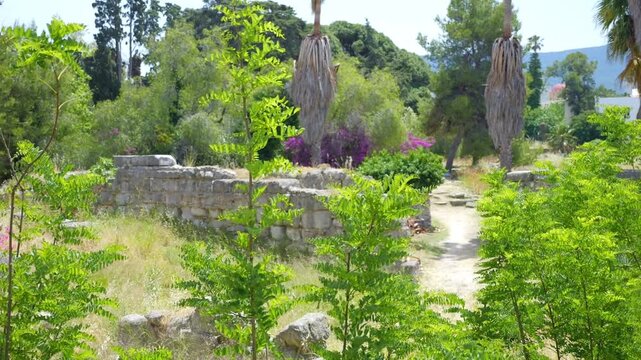 Ancient agora ruins in Kos, Greece, surrounded by lush greenery in slow motion 60fps