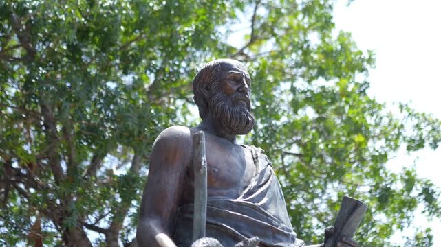 A statue of Hippocrates surrounded by trees in slow motion 60fps
