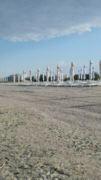 Closed beach umbrellas on sand in summer