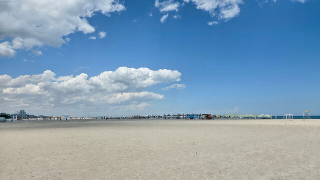 Wide view of a sandy beach under a blue sky