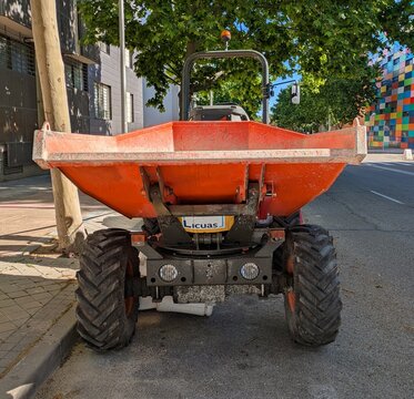 Maquinaria industrial. Vista frontal de un dumper color naranja, con plataforma de conducci&oacute;n abierta y una tolva frontal basculante, aparcado en Madrid, Espa&ntilde;a, 16 de mayo de 2026