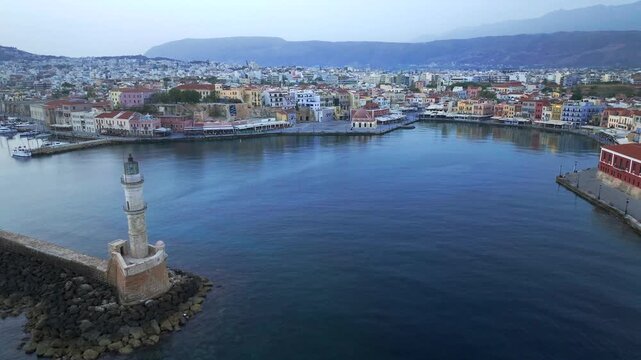  View of Chania with the amazing lighthouse, mosque, venetian shipyards, Crete, Greece.Waves crashing on lighthouse, Beautiful Greece and best scenic places - panorama