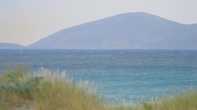 View of Kalymnos island from Kos, Greece, surrounded by trees and the sea in slow motion 60fps
