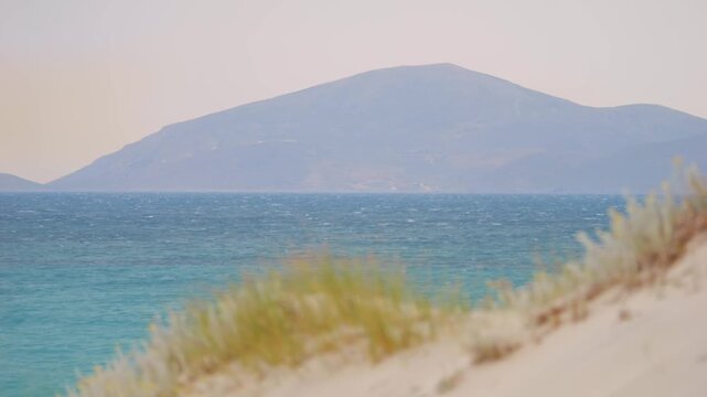 View of Kalymnos island from Kos, Greece, surrounded by trees and the sea in slow motion 60fps