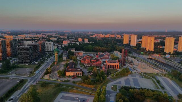 Aerial drone view of Spodek Arena and the Katowice city center during a colorful sunset. Modern architecture, urban skyline and golden hour over Silesia, Poland.
