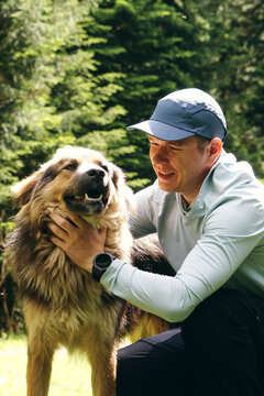 A young, happy man hugs his dog and smiles. Walking a pet, owner and dog