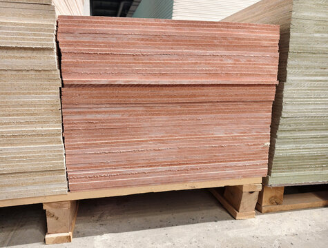 Magnesite boards stacked on pallets in a building supply supermarket with construction sheet material and hardware store interior display