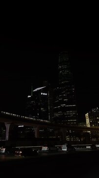 Riyadh, Saudi Arabia - July 2026: Riyadh Metro train passing on the bridge at night in front of illuminated skyscrapers at King Abdullah Financial District KAFD.