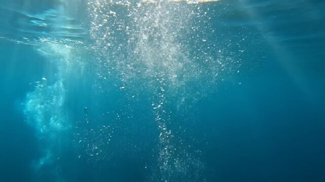 Underwater Bubbles and Light Rays: Captivating underwater scene with sun rays piercing the deep blue water, illuminating rising bubbles. A tranquil and ethereal display of nature's beauty.