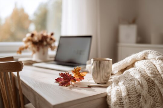 Cozy Autumn Desk Setup with Laptop, Coffee Mug, and Fall Leaves