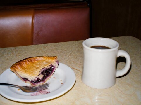  Candid lo-fi 35mm film snapshot of half eaten pie and black coffee cup on retro diner table