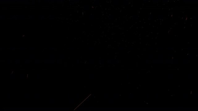 small tiny pieces of volcanic fire ash and embers floating upwards naturally in the night sky realistic subtle  fragments from a  bonfire or blazing inferno rising upward in the wind 4K video overlay