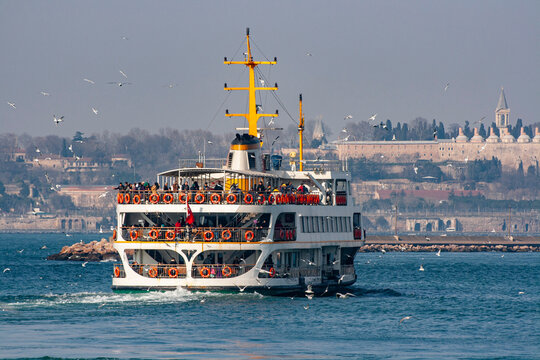 Traditional public passenger ferry boat sailing on the Bosphorus strait with historical peninsula in Istanbul