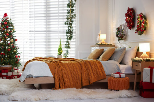 Beautiful Christmas decor and comfortable bed in bedroom. Interior design