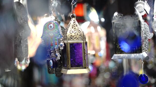 Close up of a purple glass Arabic lantern and evil eye charm with beautiful blurry bokeh background lights.