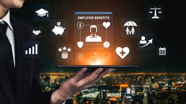 Businessman in Suit Holding Laptop Displaying Employee Benefits Technology with Icons of Finance, Health, and Career Advancement in Urban Skyline Background Haptic.