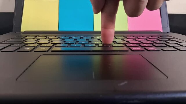 Human finger pressing laptop keyboard keys in smooth motion video footage