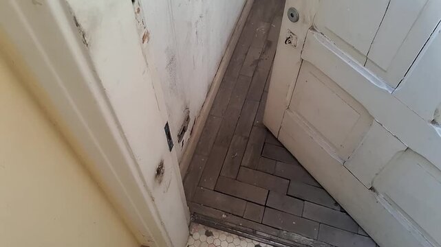Old wooden door opening to reveal vintage parquet flooring motion footage