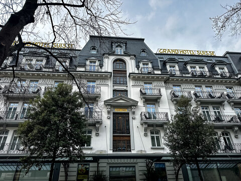 Montreux, Switzerland - 11.03.2026. Low-angle exterior shot of the historic Grand Hotel Suisse Majestic in Montreux, Switzerland. The white facade displays ornate Belle &Eacute;poque architectural design, ro