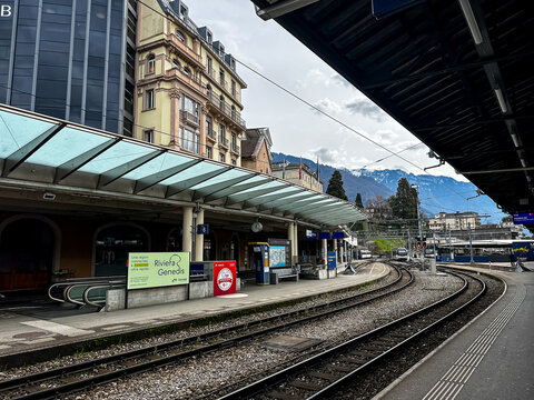 Montreux, Switzerland - 11.03.2026. High-angle perspective of the curved railway tracks and platforms at the Montreux train station (Gare de Montreux) in Switzerland. The covered platform features mod