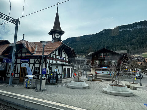 Zweisimmen, Switzerland - 11.03.2026. High-angle perspective shot of the traditional timber-framed (half-timbered) railway station building at Zweisimmen station. The picturesque structure features a 
