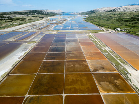 Aerial drone view of Pag Island salt pans or Solana Pag, Croatia. Colorful Salt Evaporation Ponds and Adriatic Landscape