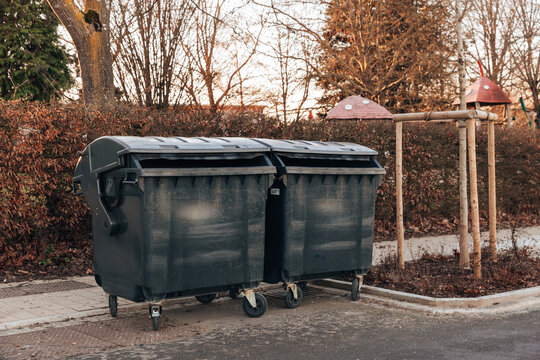 Two large Euro containers on the city street in the evening.