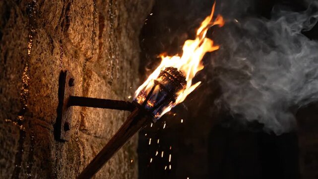 Burning torch on stone wall, medieval castle, fire sparks, smoke, dark, ancient, atmospheric