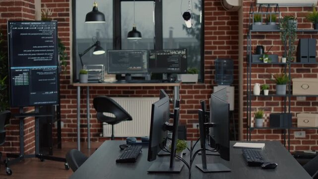 Unattended software office desk displays active code parsing across computer monitors, presenting data processing, automation and development infrastructure