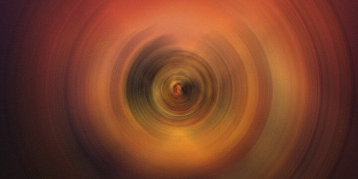 Abstract circular motion background with orange yellow and brown radial light streaks.