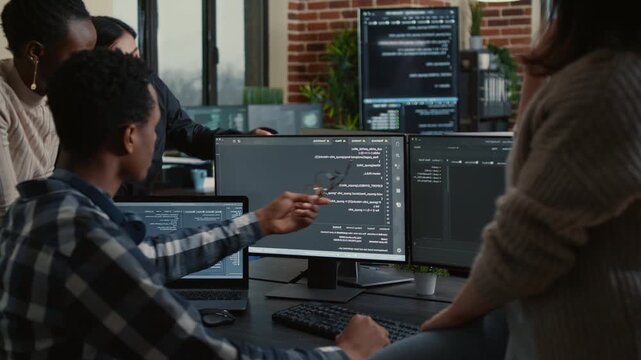 Software development team investigates source code errors on a laptop screen, comparing algorithms and debugging problems during office collaboration