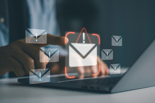Cybersecurity concept showing phishing email alert icons on laptop screen with businessman hand selecting suspicious message, spam detection, email security, cyber attack prevention, data protection.