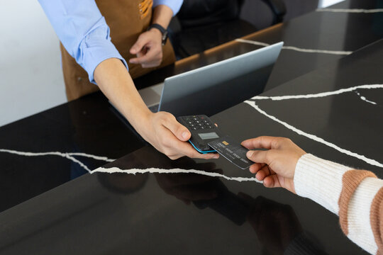 African American cashier and customer making payment on marble counter with reader and black card