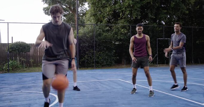 Diverse males passing from gray, purple tank driving baseline with ball scoring on backyard court