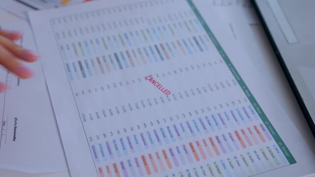 Cancelled flight airline schedule travel document hand airport delay timetable with passenger information, printed paperwork, red stamp, desk planning detail, route report, organizer chart