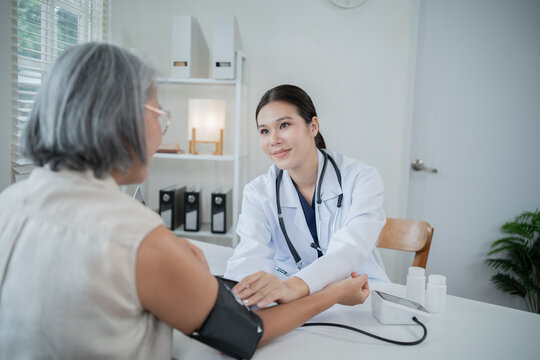 An Asian nurse is measuring the blood pressure of an elderly patient, providing attentive health check-ups, diagnosis, and treatment, as well as professional advice on wellness and elderly care.