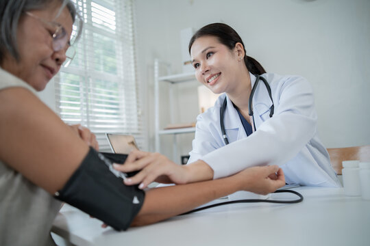 An Asian nurse is measuring the blood pressure of an elderly patient, providing attentive health check-ups, diagnosis, and treatment, as well as professional advice on wellness and elderly care.