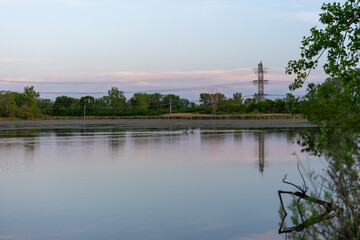 Fototapeta premium Scenic lake at sunset with power lines in distance