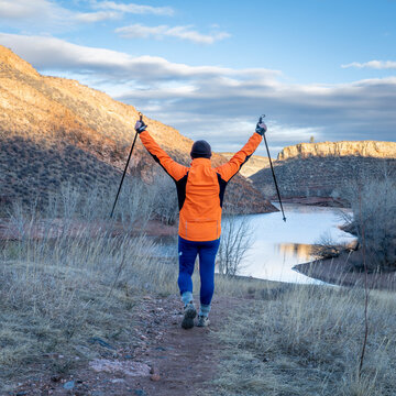 senior male hiker with trekking poles in Lory State Park in Colorado foothills with Horsetooth Reservoit in background