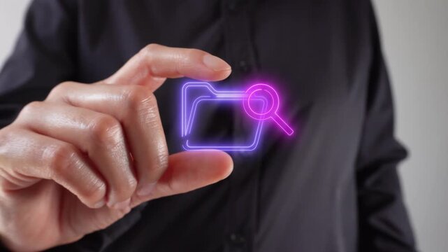 Searching for documents and files. Close-up of a woman's hands holding a virtual folder icon and a magnifying glass between her two fingers.